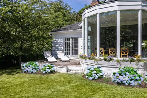 a front view of a house with a yard table and chairs