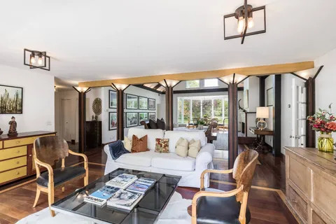 a living room with furniture a rug and a large window
