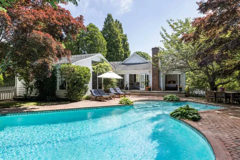 a view of a house with swimming pool and sitting area