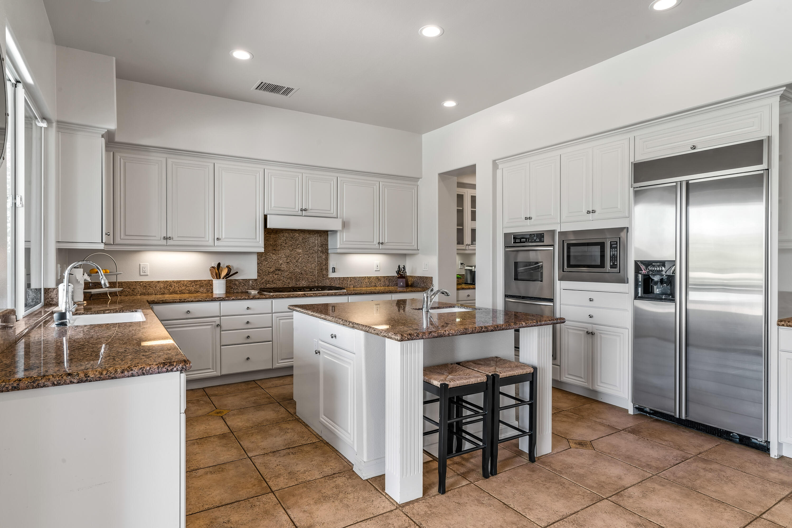 362 Loch Lomond Road Rancho Mirage, CA 92270 - Photo 19 of 26 a kitchen with granite countertop a sink stainless steel appliances and white cabinets