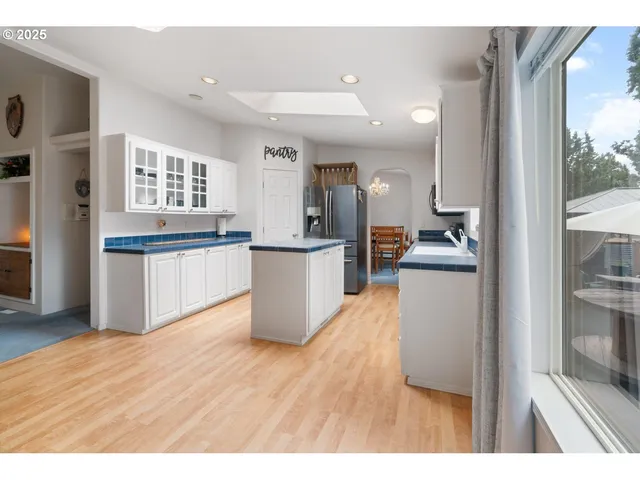 a kitchen with stainless steel appliances granite countertop a refrigerator a sink dishwasher and a stove with wooden floor