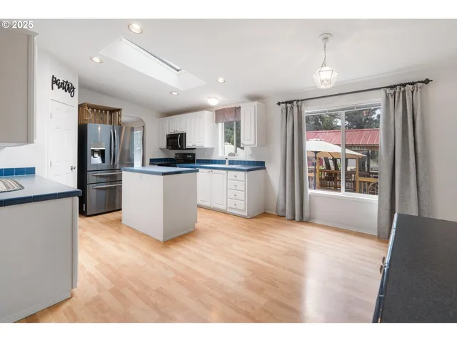 a kitchen with granite countertop a stove top oven a sink and a refrigerator