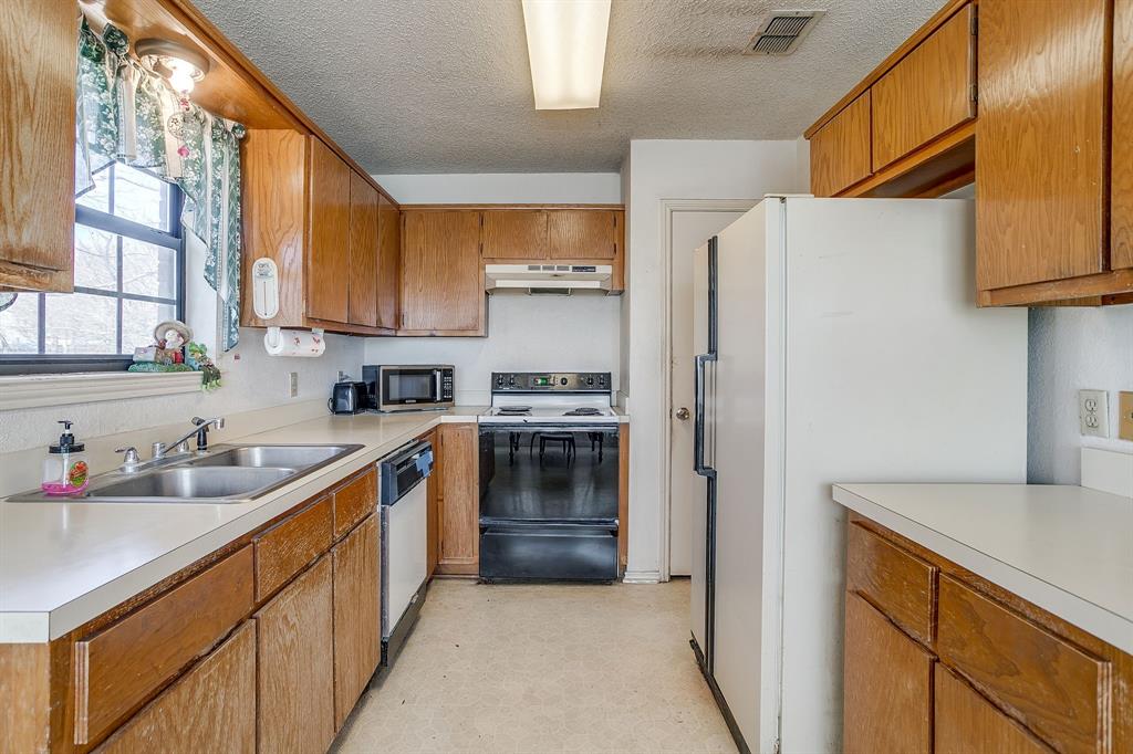 3019 Sunrise Trail Weatherford, TX 76088 - Photo 15 of 40 a kitchen with stainless steel appliances a refrigerator sink and cabinets