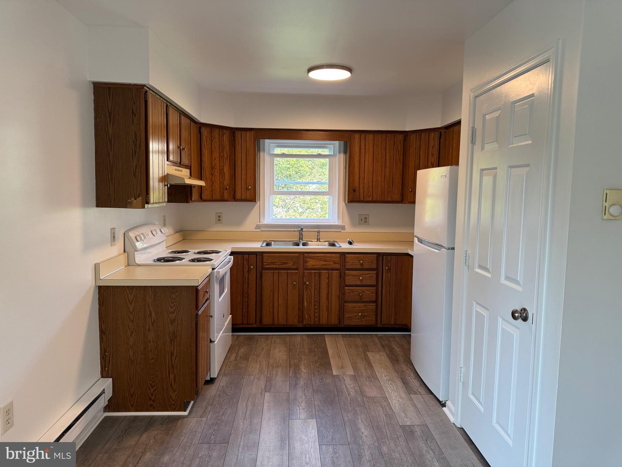 a kitchen with a sink a stove a refrigerator and a window