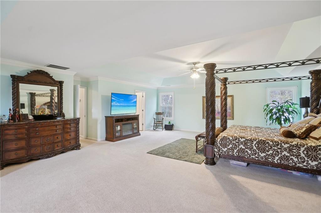 419 Long Shore Way Newnan, GA 30265 - Photo 15 of 29 a bedroom with a bed and a mirror on dresser