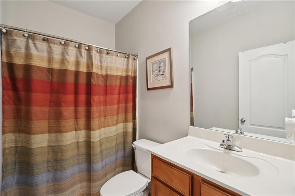 419 Long Shore Way Newnan, GA 30265 - Photo 23 of 29 a bathroom with a sink a toilet a shower curtain and a mirror