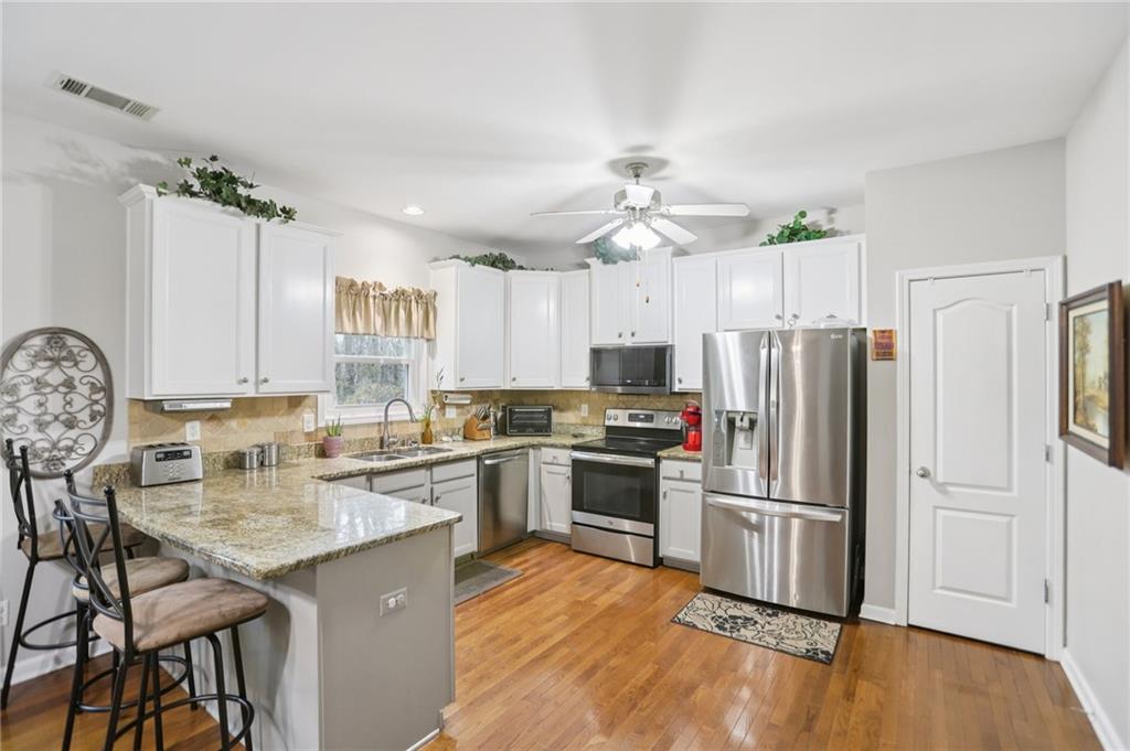 419 Long Shore Way Newnan, GA 30265 - Photo 6 of 29 a kitchen with granite countertop a center island stainless steel appliances cabinets and a center island