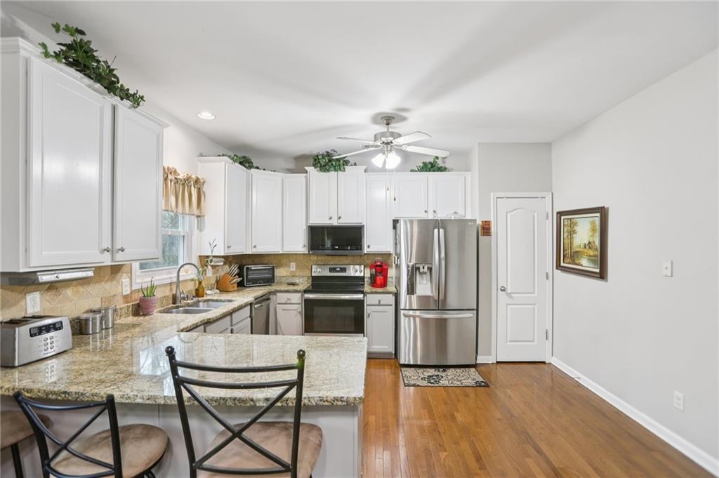 419 Long Shore Way Newnan, GA 30265 - Photo 7 of 29 a kitchen with kitchen island white cabinets and stainless steel appliances