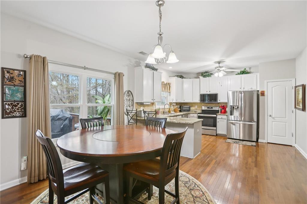 419 Long Shore Way Newnan, GA 30265 - Photo 8 of 29 a dining room with stainless steel appliances kitchen island granite countertop a dining table and chairs
