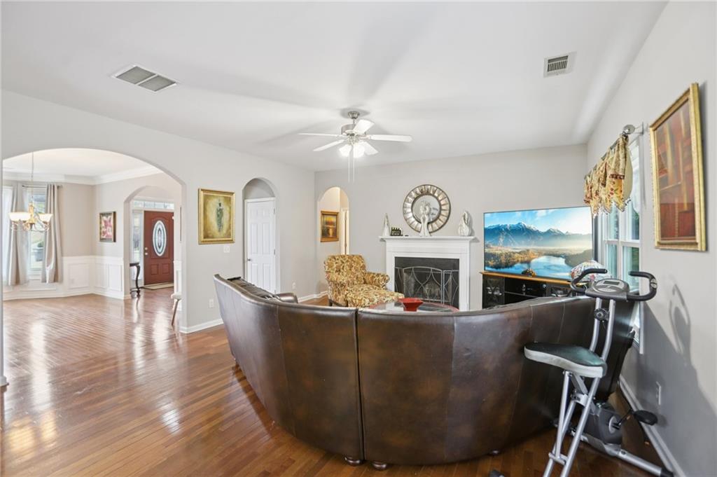 419 Long Shore Way Newnan, GA 30265 - Photo 10 of 29 a living room with furniture a fireplace and a chandelier