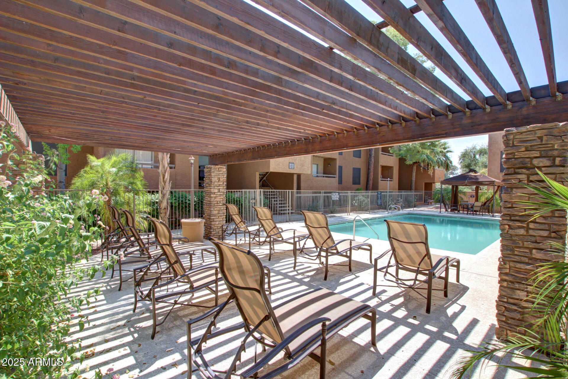 2625 East Indian School Road, Unit 238 Phoenix, AZ 85016 - Photo 26 of 29 a view of a patio with table and chairs and couches with wooden roof and stairs