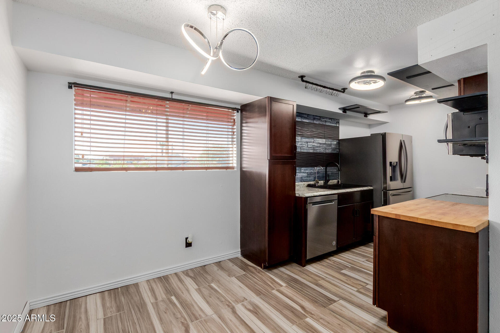 2625 East Indian School Road, Unit 238 Phoenix, AZ 85016 - Photo 5 of 29 a kitchen with stainless steel appliances granite countertop a stove a refrigerator and a microwave