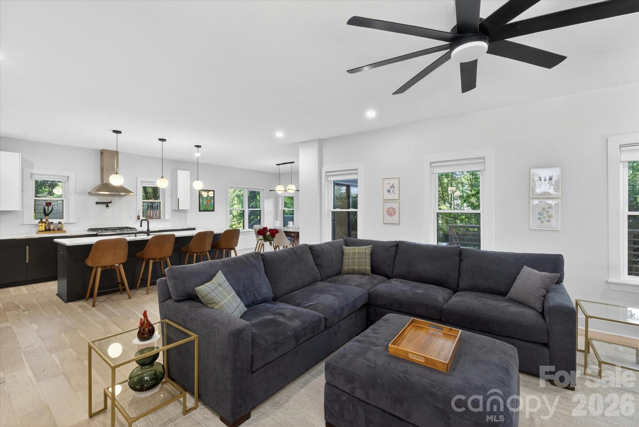 1608 Chippendale Road Charlotte, NC 28205 - Photo 19 of 46 a living room with couches a fireplace and a kitchen view with wooden floor