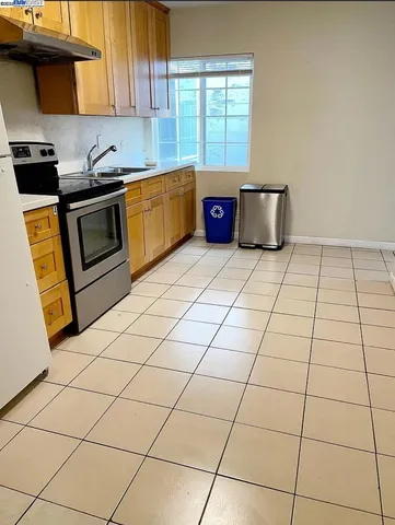 a kitchen with granite countertop a stove a sink and a microwave
