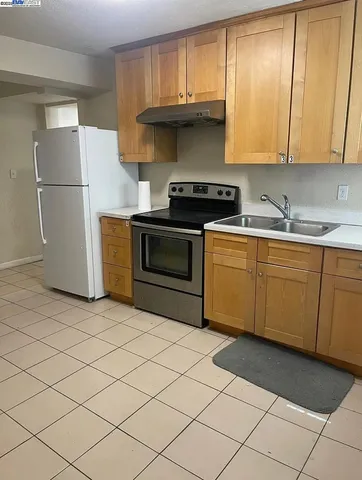a kitchen with a sink a refrigerator and cabinets