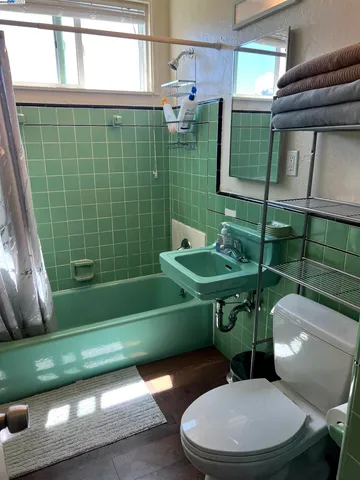 a bathroom with a toilet a sink and mirror
