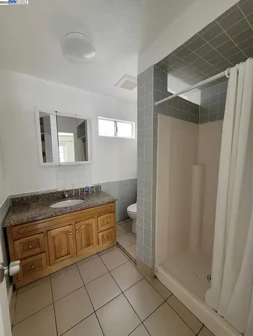 a bathroom with a granite countertop sink a toilet and a shower