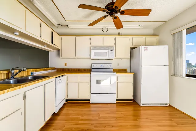 a kitchen with stainless steel appliances white cabinets and wooden floors