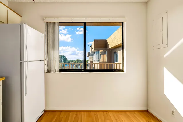 a kitchen with a refrigerator a stove and wooden floor