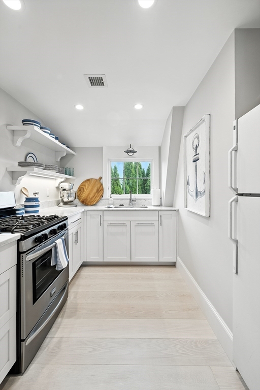 131 Front Street Marblehead, MA 01945 - Photo 25 of 41 a kitchen with stainless steel appliances granite countertop a stove a sink and a refrigerator