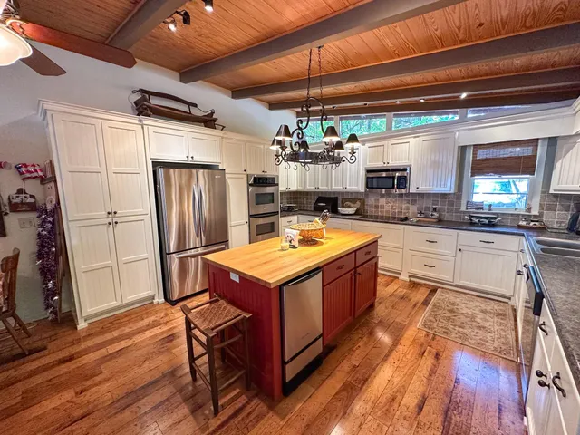 a dining room with furniture a chandelier and wooden floor