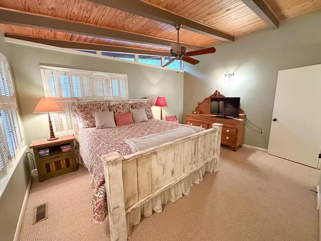 a bedroom with a bed and a ceiling fan