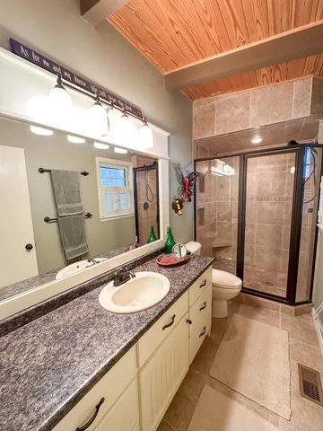 a bathroom with a granite countertop sink toilet and shower