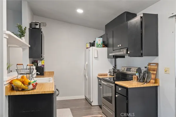 a kitchen with stainless steel appliances granite countertop a refrigerator and a stove top oven