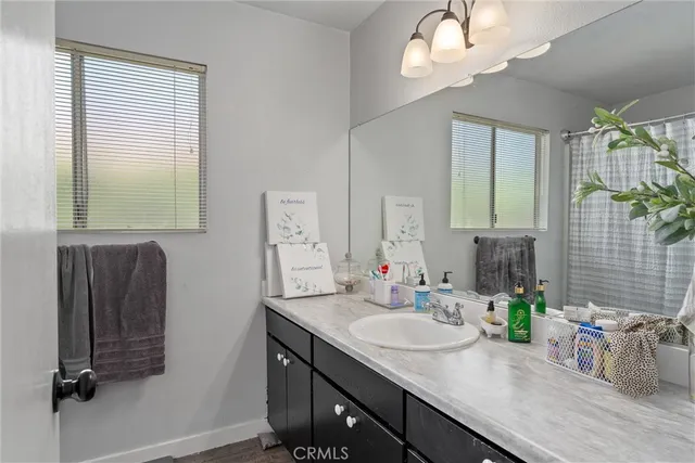 a bathroom with a granite countertop sink a mirror and a shower