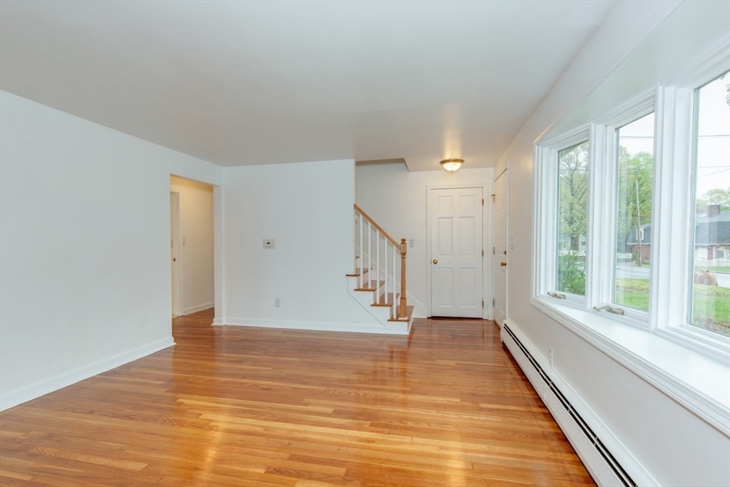 28 McKenney Circle Andover, MA 01810 - Photo 17 of 42 a view of an empty room with wooden floor and a window