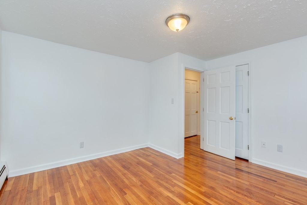 28 McKenney Circle Andover, MA 01810 - Photo 23 of 42 a view of an empty room with wooden floor and a window