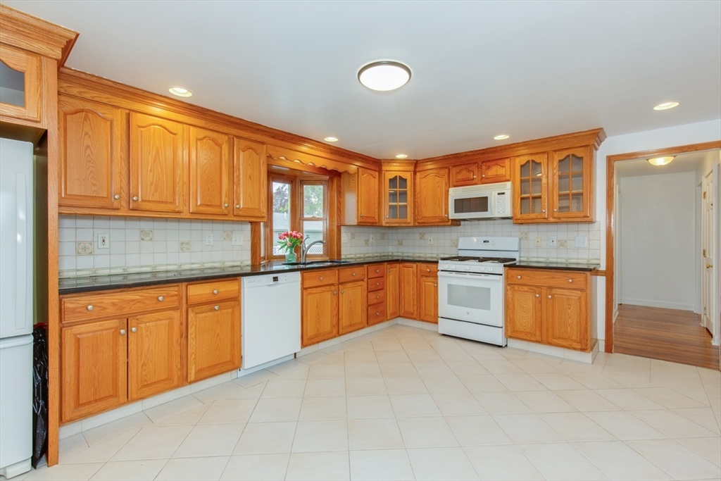 28 McKenney Circle Andover, MA 01810 - Photo 9 of 42 a kitchen with stainless steel appliances granite countertop a stove sink and cabinets