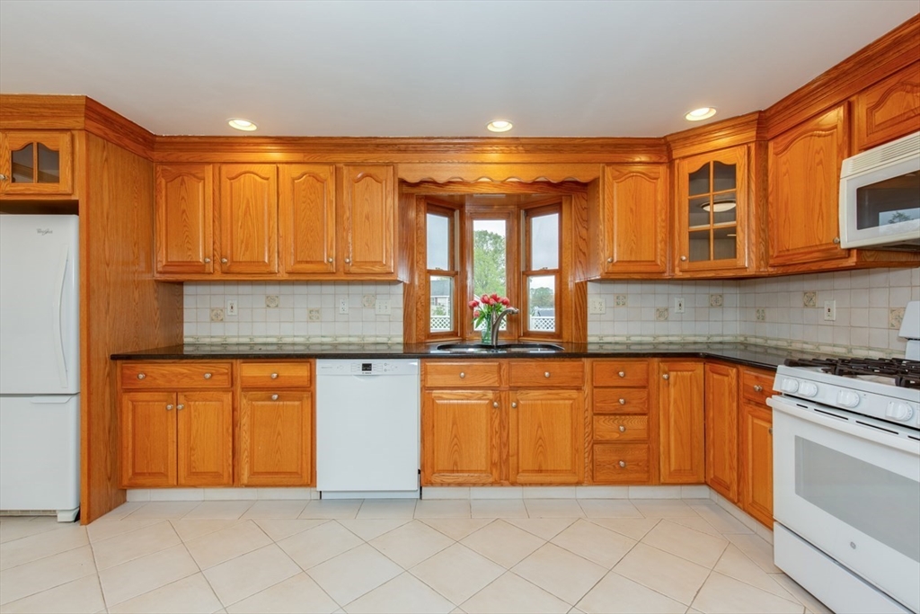 28 McKenney Circle Andover, MA 01810 - Photo 10 of 42 a kitchen with stainless steel appliances granite countertop a stove a sink and a refrigerator