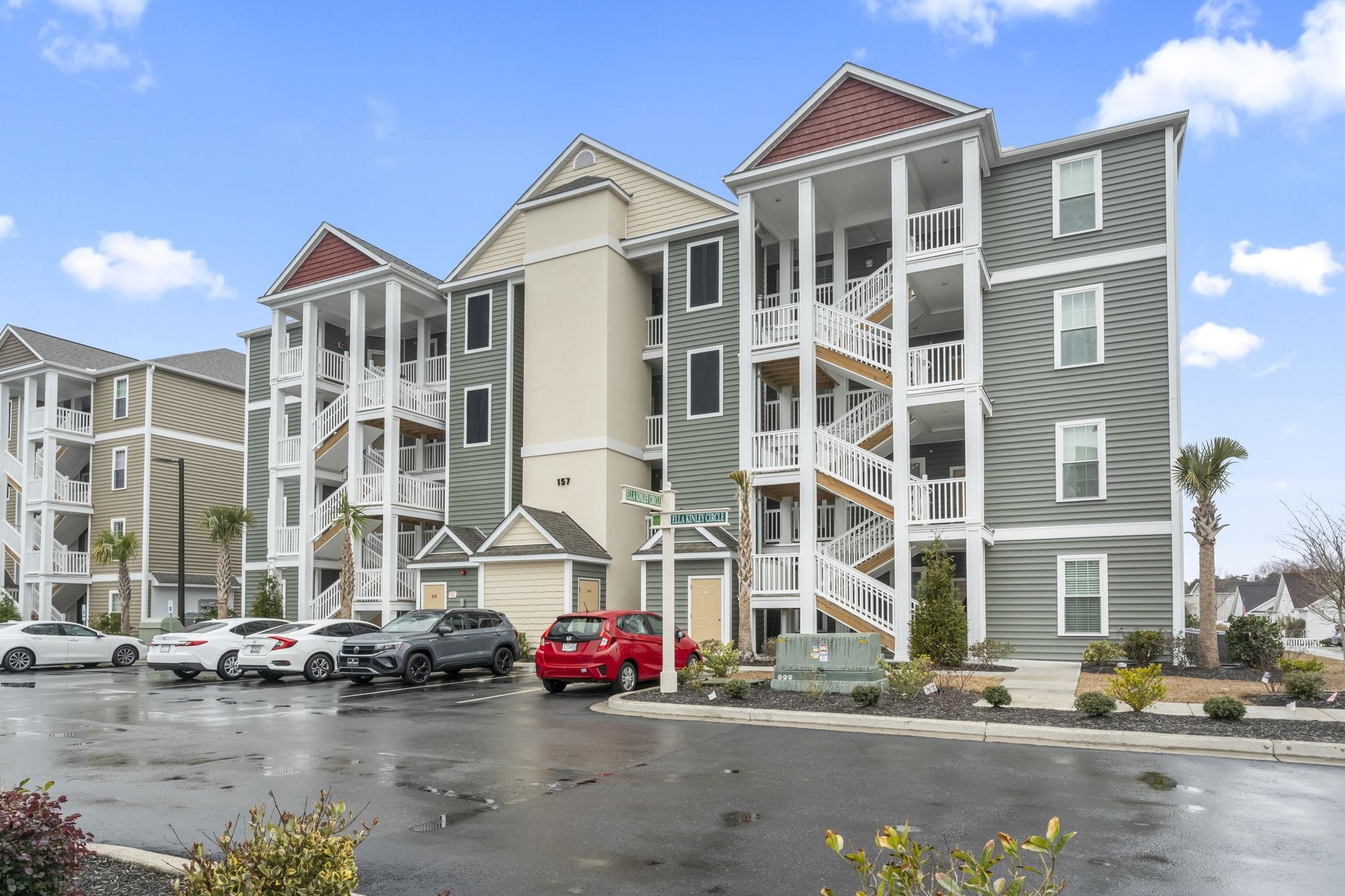 View of apartment building / complex featuring uncovered parking