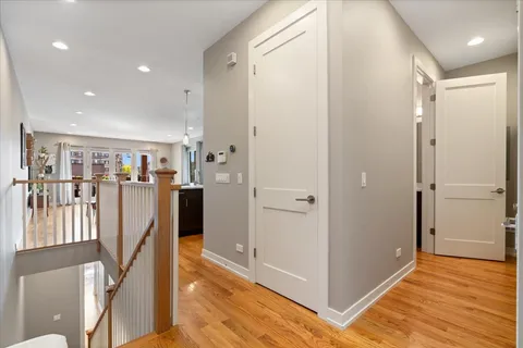 a view of a hallway with wooden floor and staircase