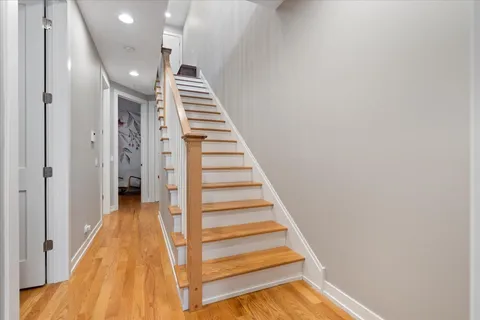 a view of entryway and hall with wooden floor