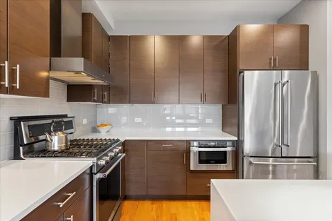 a kitchen with kitchen island a counter top space a stove and a refrigerator
