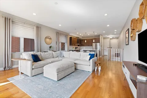 a living room with furniture and a wooden floor