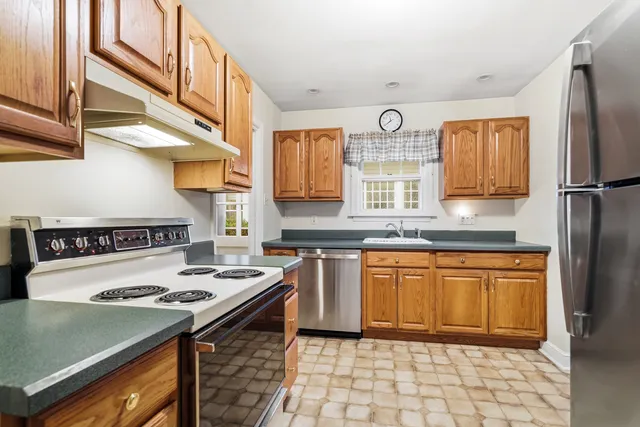 a kitchen with stainless steel appliances granite countertop a stove a sink and a refrigerator