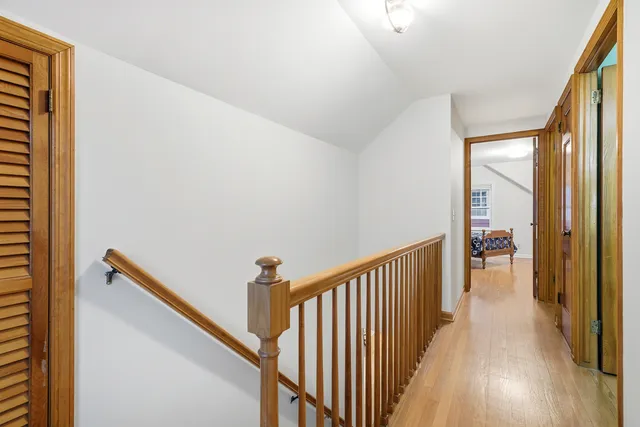 a view of a hallway with wooden floor and staircase