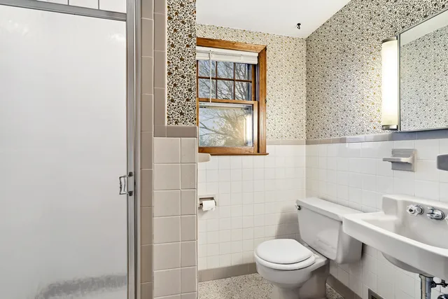 a bathroom with a toilet sink and mirror