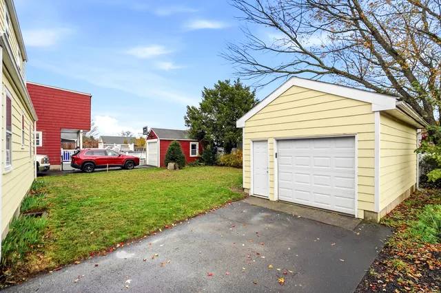 a front view of a house with a garden and trees