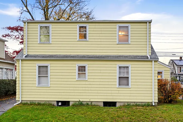 a view of a house with a yard and potted plants