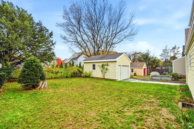 a front view of a house with a yard and trees