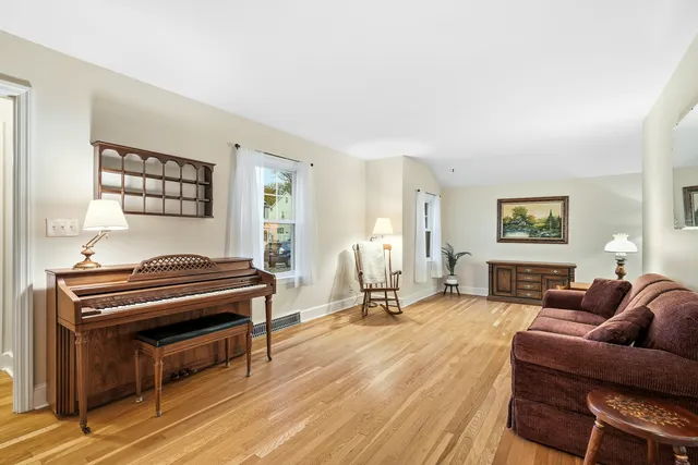 a living room with furniture a piano and a window