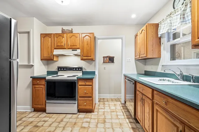 a kitchen with stainless steel appliances granite countertop a stove a sink and a refrigerator