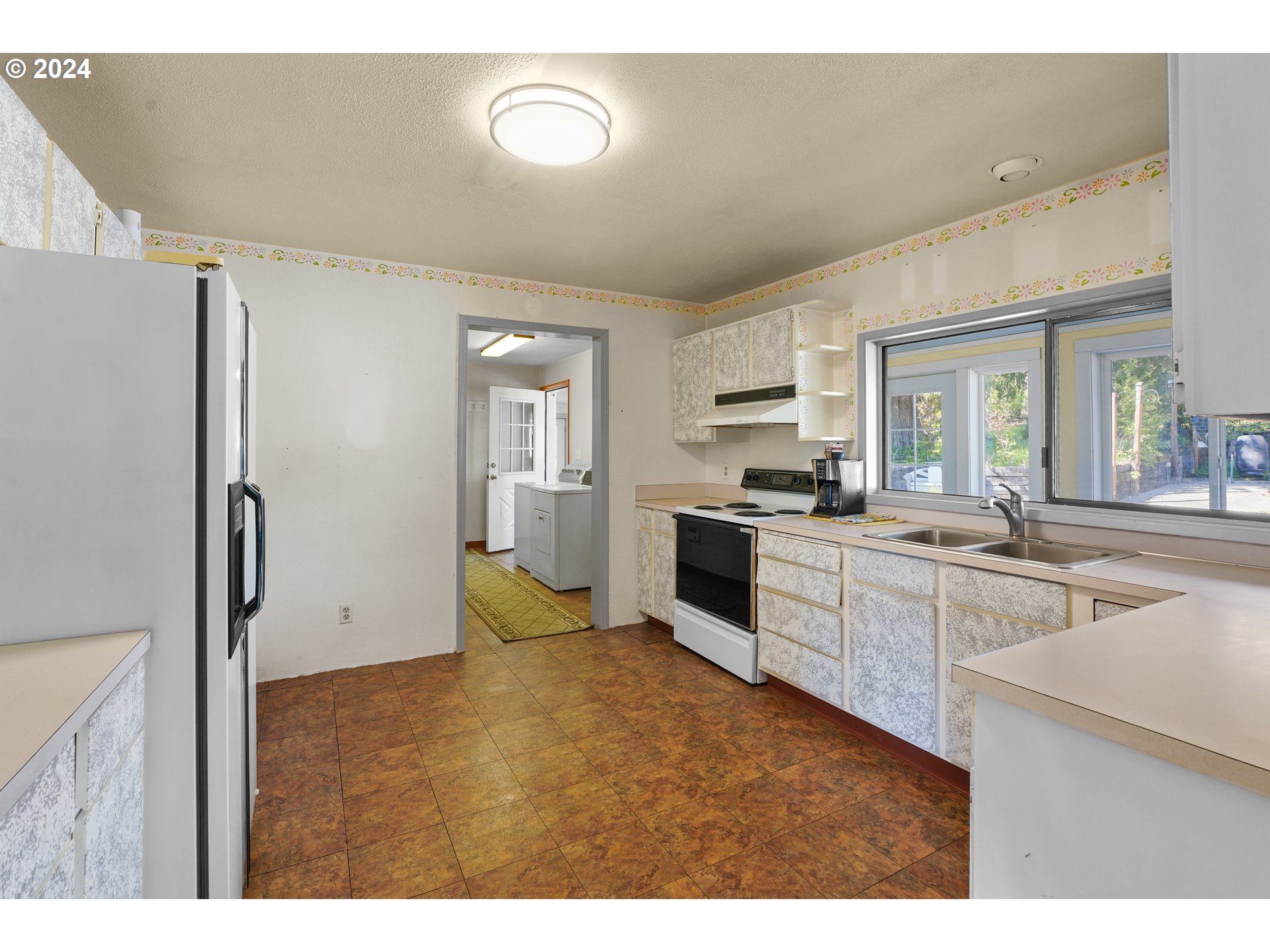 18787 Southeast Sunnyside Road Damascus, OR 97089 - Photo 11 of 36 a kitchen with white cabinets and appliances