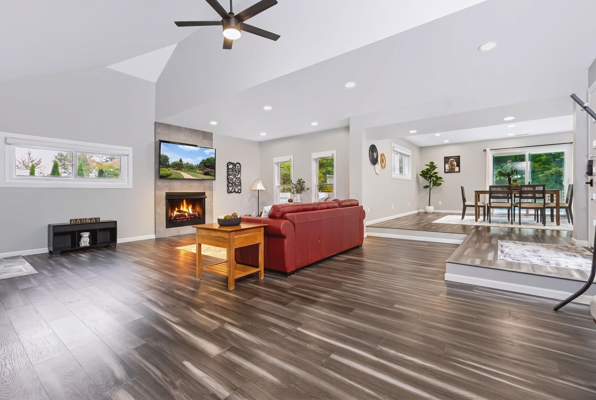 7140 Cook Road Powell, OH 43065 - Photo 33 of 87 Vaulted ceiling with a ceiling fan, recessed lighting, wood-finish flooring, and a fireplace with a stone-finish surround