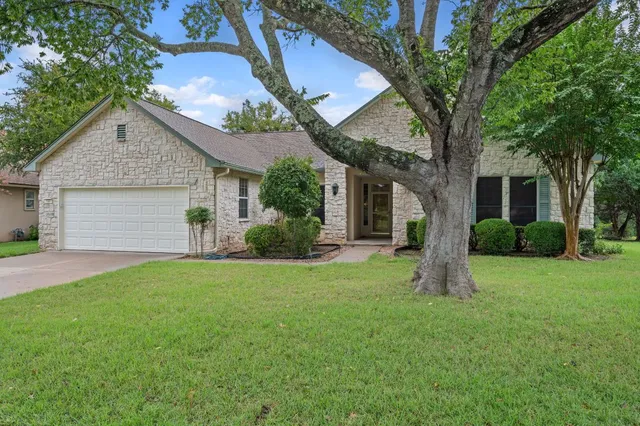 a front view of a house with a garden and yard