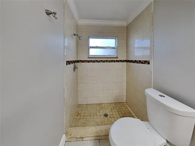 a toilet sitting in a bathroom next to a window